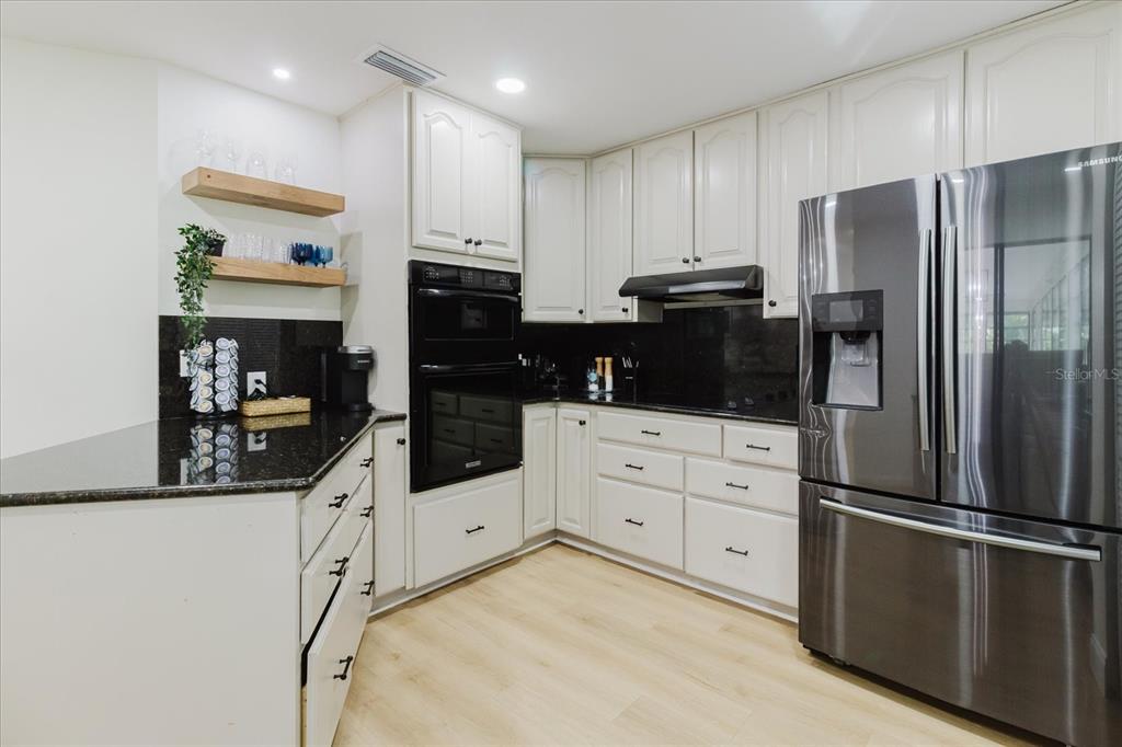 8304 Revels Road Riverview, FL 33569 - Photo 18 of 99 a kitchen with granite countertop a refrigerator and a stove top oven