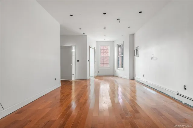 a view of an empty room with wooden floor