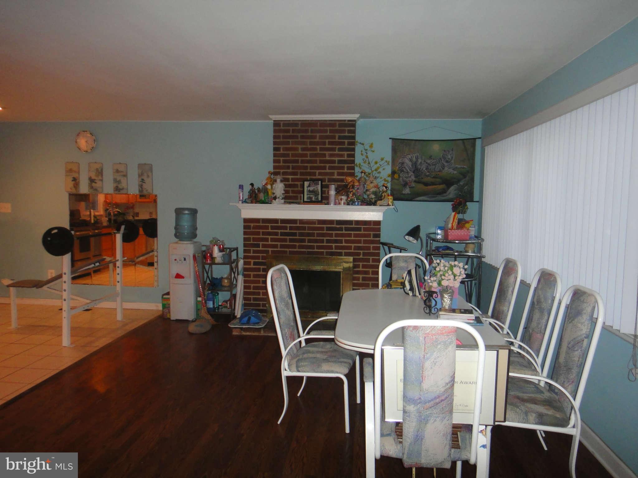 6221 Frontier Drive Springfield, VA 22150 - Photo 7 of 18 a dining room with furniture a fireplace and wooden floor