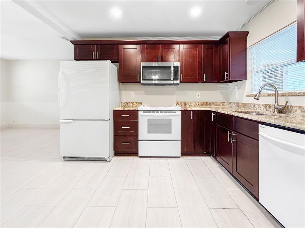 133 18th Street Northwest Ruskin, FL 33570 - Photo 12 of 25 a kitchen with stainless steel appliances granite countertop a refrigerator a sink a stove a microwave and cabinets
