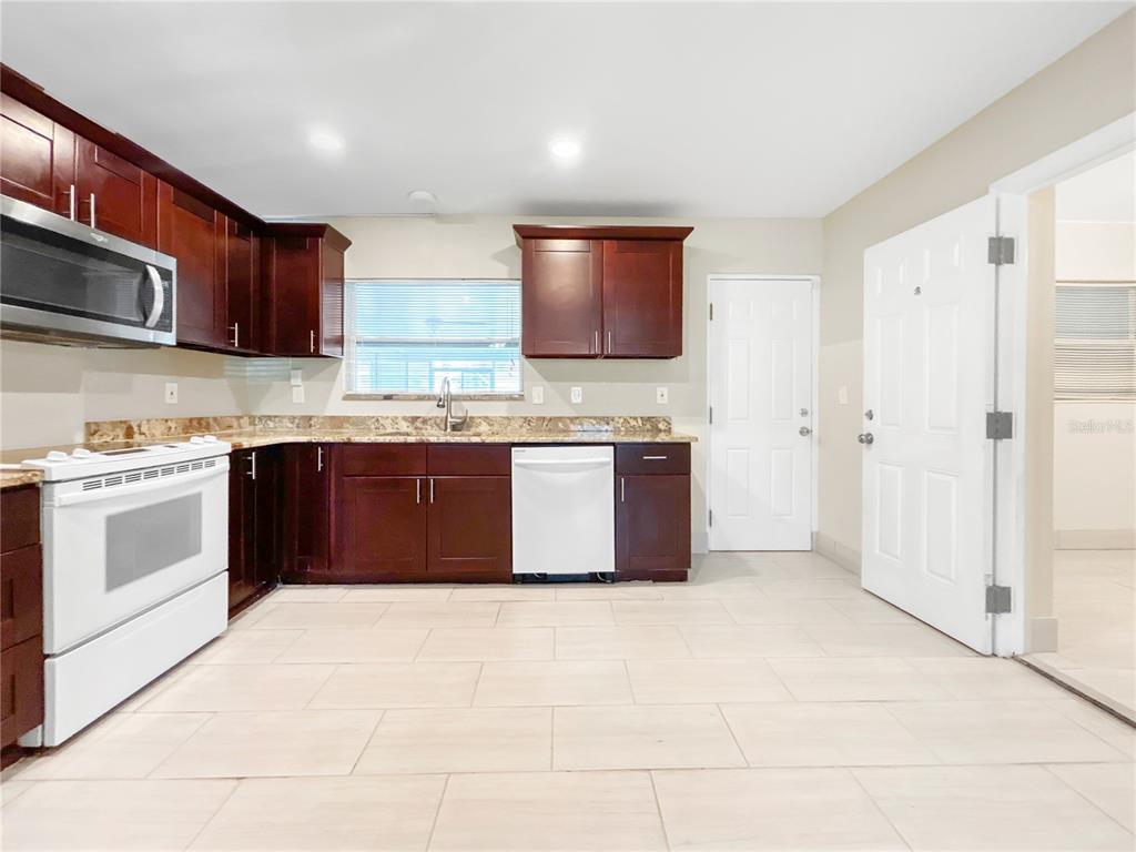 133 18th Street Northwest Ruskin, FL 33570 - Photo 7 of 25 a large kitchen with stainless steel appliances granite countertop a stove a sink dishwasher and a refrigerator