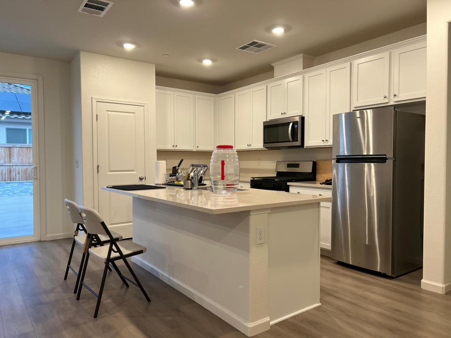 1808 Apiary Way Hughson, CA 95326 - Photo 4 of 20 a kitchen with stainless steel appliances a refrigerator stove microwave and cabinets