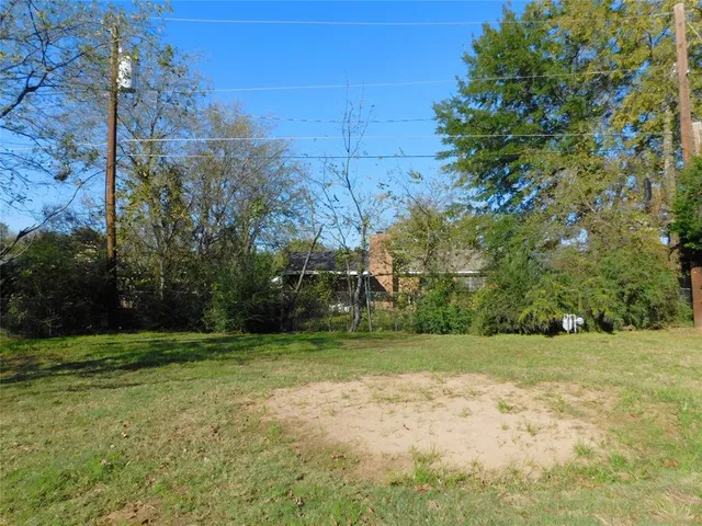 a view of a field with trees in the background