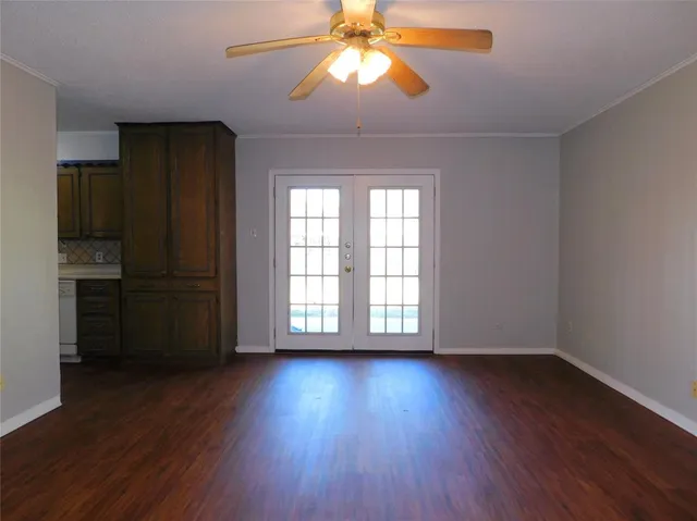 a view of an empty room with a window and wooden floor