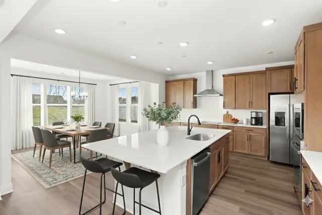 a large kitchen with kitchen island a sink table and chairs