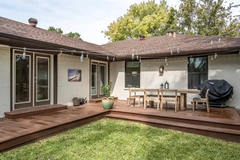 a view of a house with backyard and sitting area
