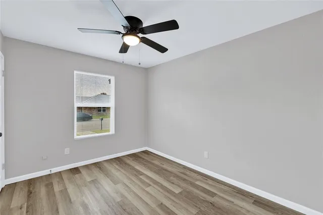 an empty room with a window and a fan
