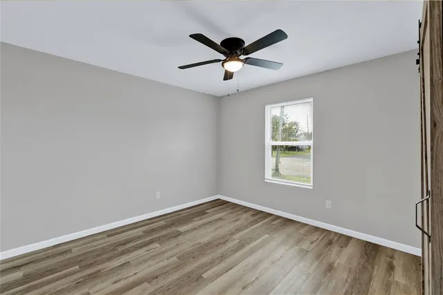 wooden floor in an empty room with a window