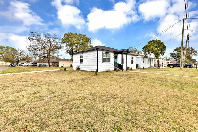 a front view of a house with a yard and trees