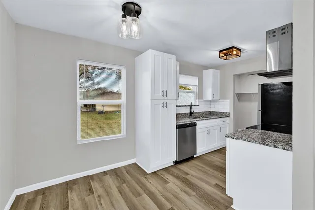 a kitchen with stainless steel appliances granite countertop a refrigerator sink and stove