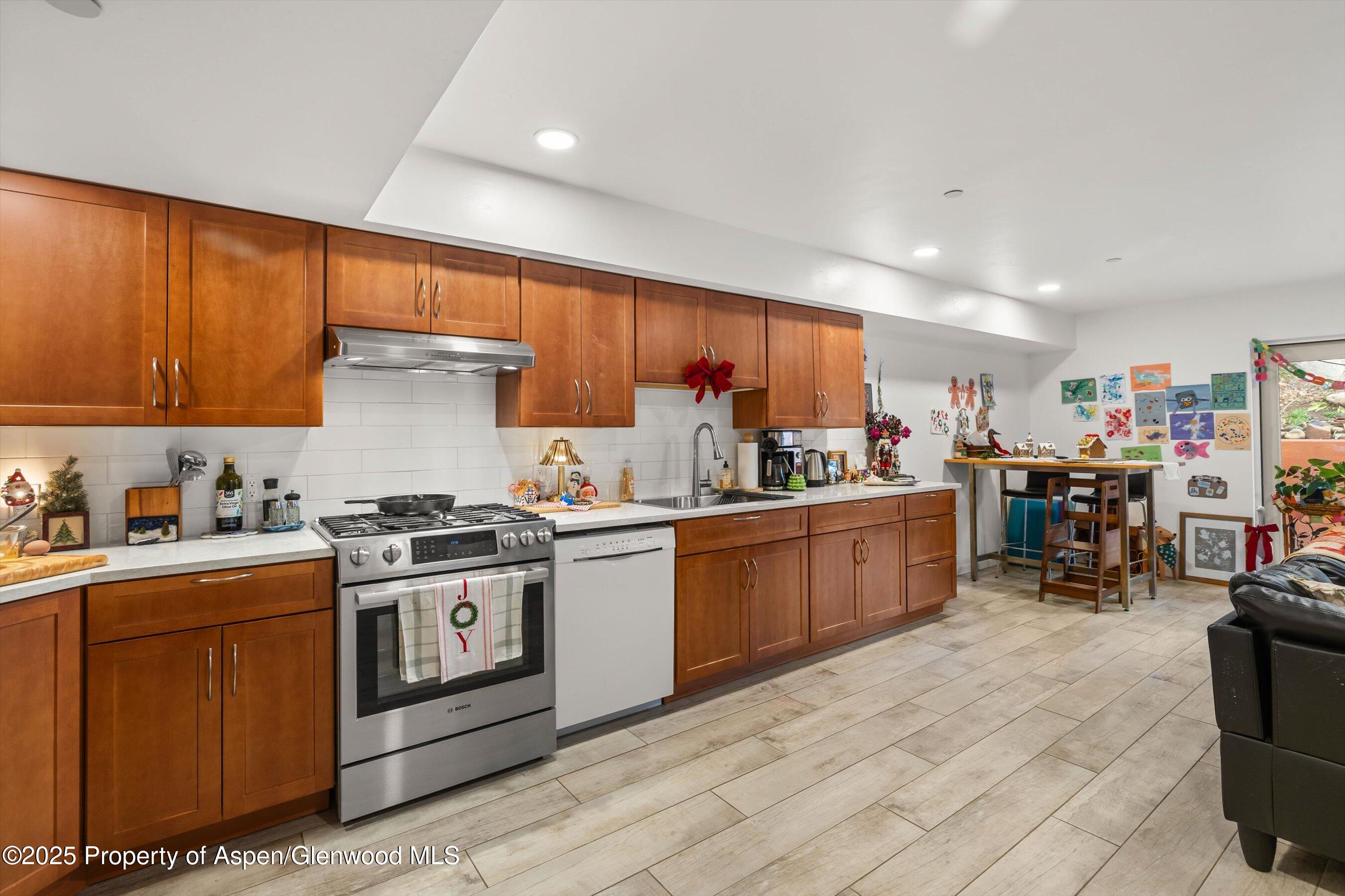 100 Midland Avenue, Unit 108 Basalt, CO 81621 - Photo 3 of 10 a kitchen with stainless steel appliances granite countertop a stove top oven a sink dishwasher and cabinets with wooden floor