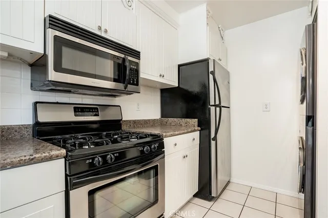 a kitchen with stainless steel appliances granite countertop a refrigerator stove and microwave