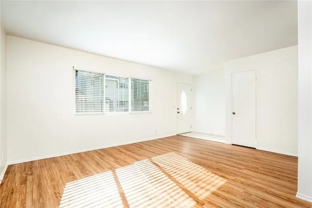 a view of a bedroom with wooden floor and window