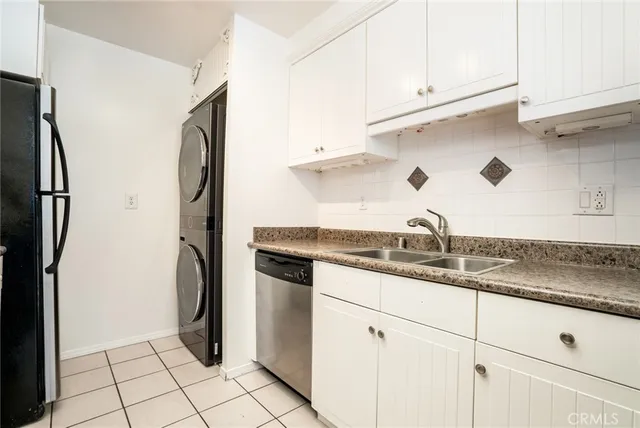 a kitchen with stainless steel appliances granite countertop a refrigerator a sink and white cabinets
