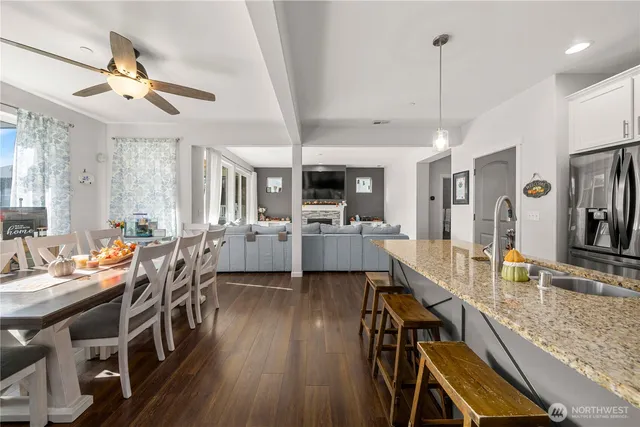 a view of a dining room and livingroom with furniture wooden floor a chandelier
