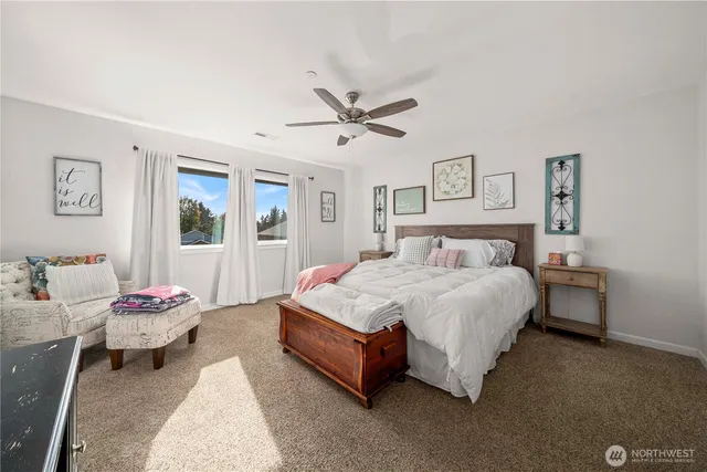 a spacious bedroom with a bed and a chandelier