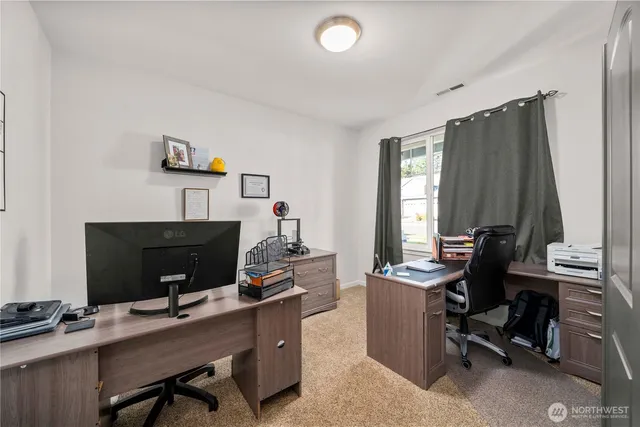 a view of a workspace with furniture and a window