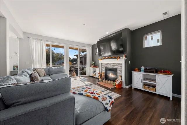 a living room with furniture a flat screen tv and a fireplace