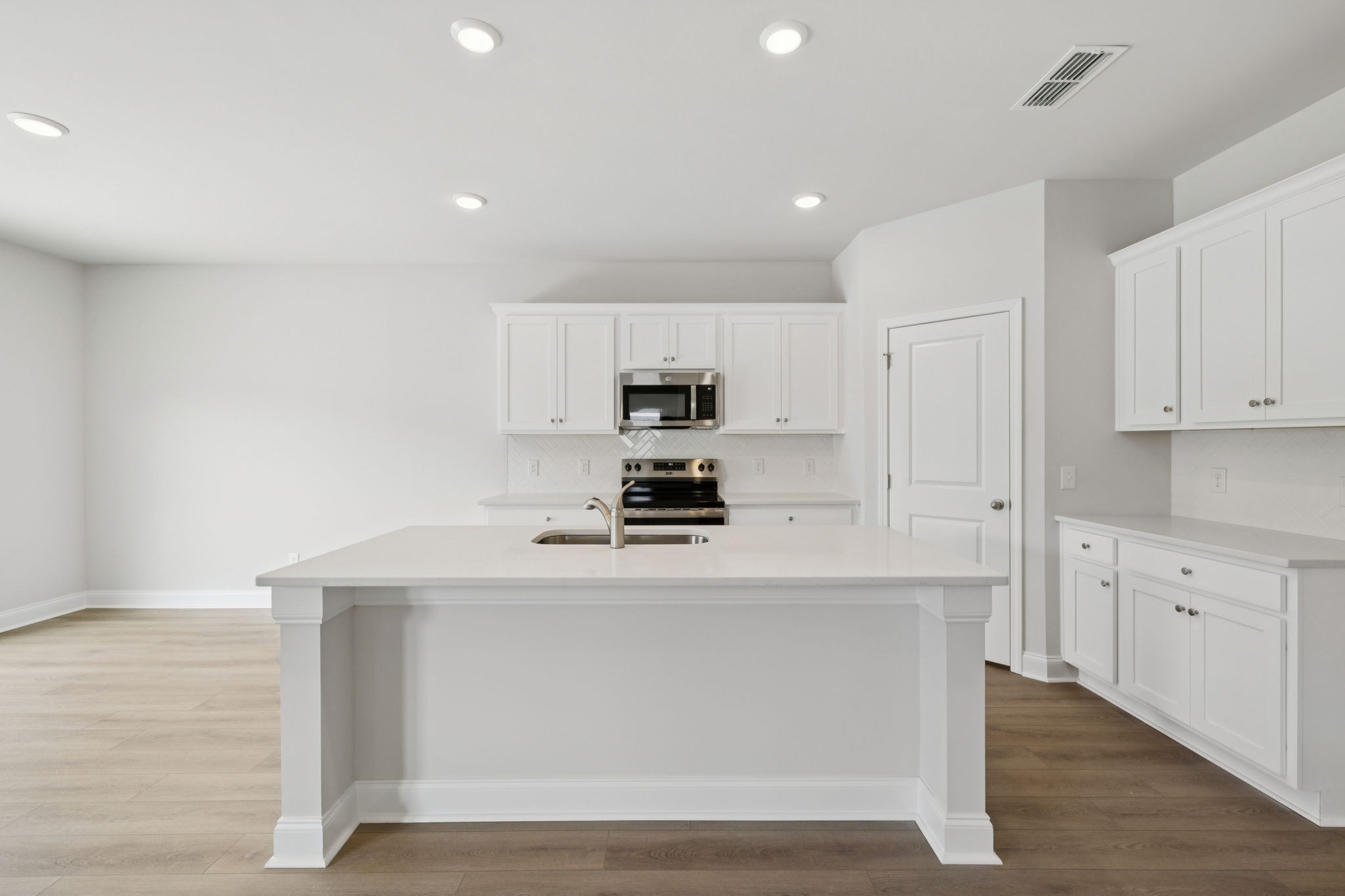 228 Limestone Way Lebanon, TN 37087 - Photo 10 of 45 a kitchen with kitchen island a stove a sink and a refrigerator