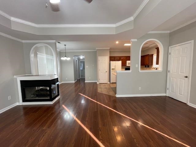 372 Beaver Road Munford, TN 38058 - Photo 3 of 18 Unfurnished living room with a multi sided fireplace, a raised ceiling, dark hardwood / wood-style flooring, ceiling fan with notable chandelier, and ornamental molding
