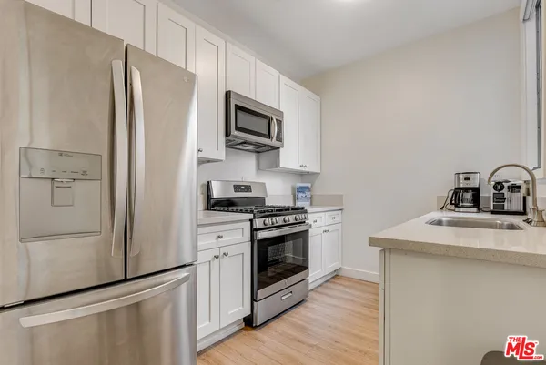 a kitchen with stainless steel appliances a refrigerator sink and microwave