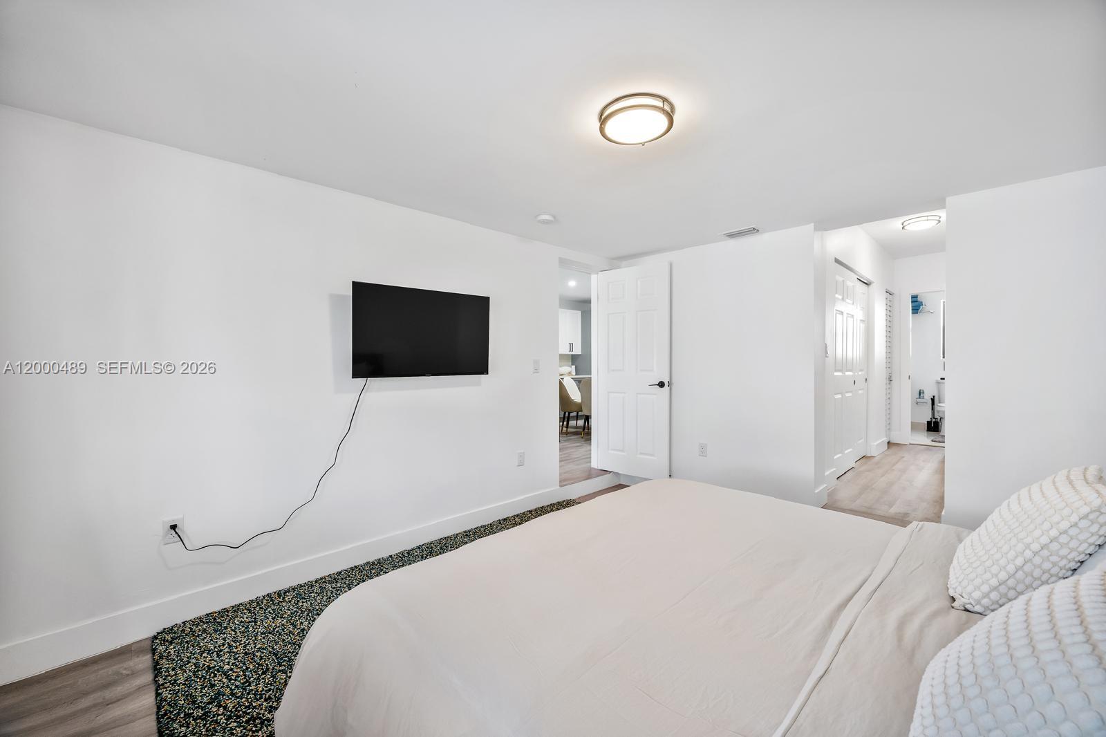 11730 Northwest 3rd Avenue Miami, FL 33168 - Photo 11 of 39 a bedroom with a bed and a flat screen tv