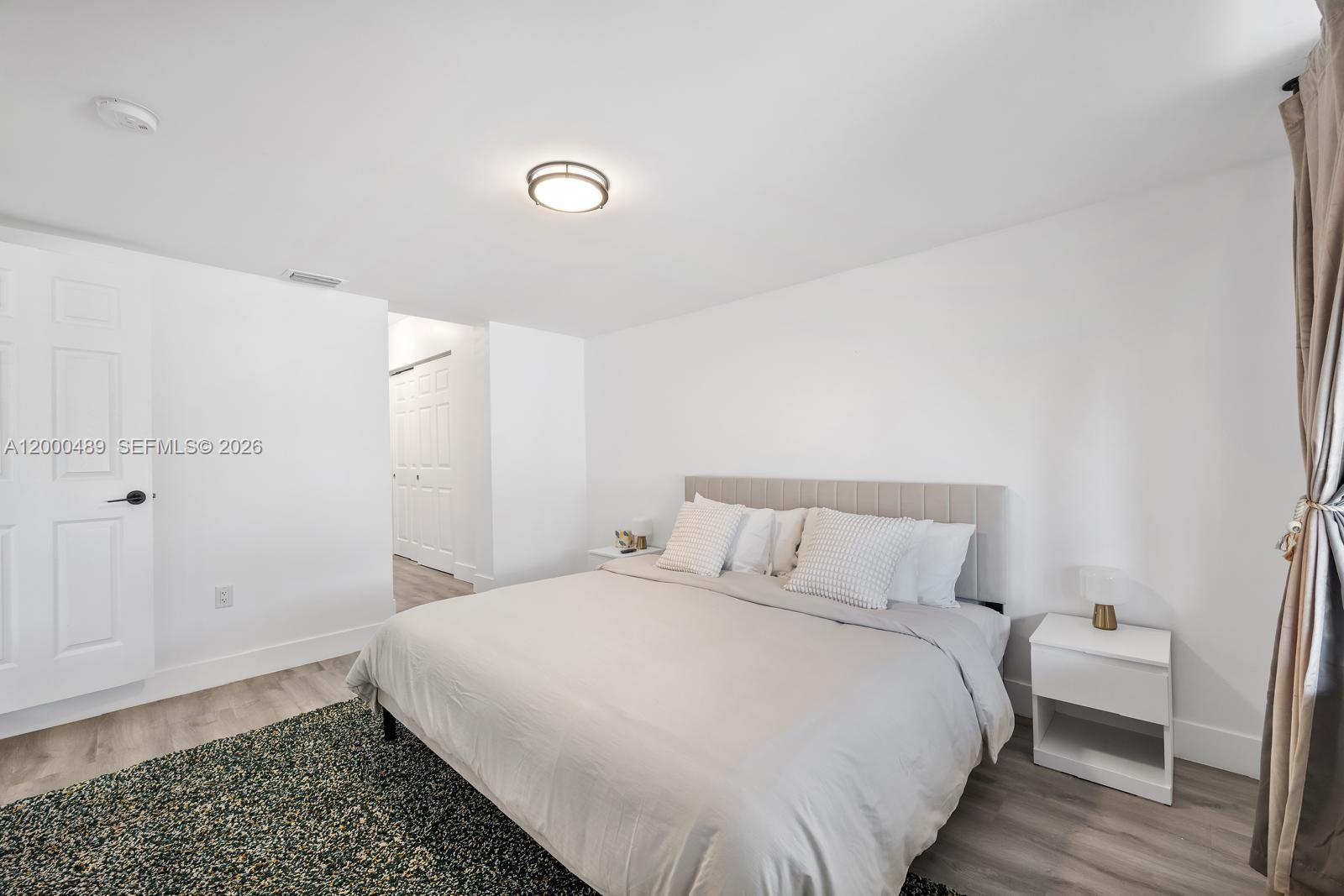 11730 Northwest 3rd Avenue Miami, FL 33168 - Photo 12 of 39 a bedroom with a bed and wooden floor
