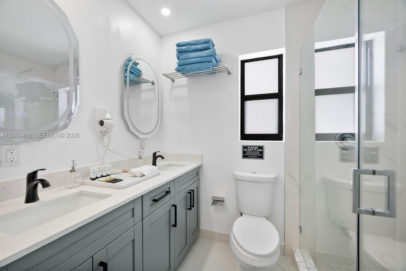 11730 Northwest 3rd Avenue Miami, FL 33168 - Photo 14 of 39 a bathroom with a toilet a sink a mirror and a shower