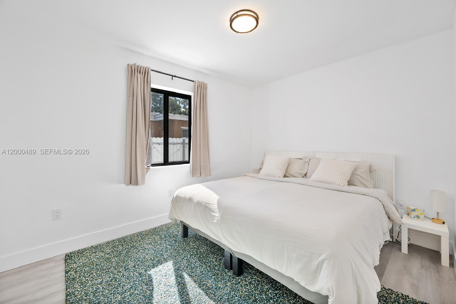 11730 Northwest 3rd Avenue Miami, FL 33168 - Photo 15 of 39 a bedroom with a bed and wooden floor