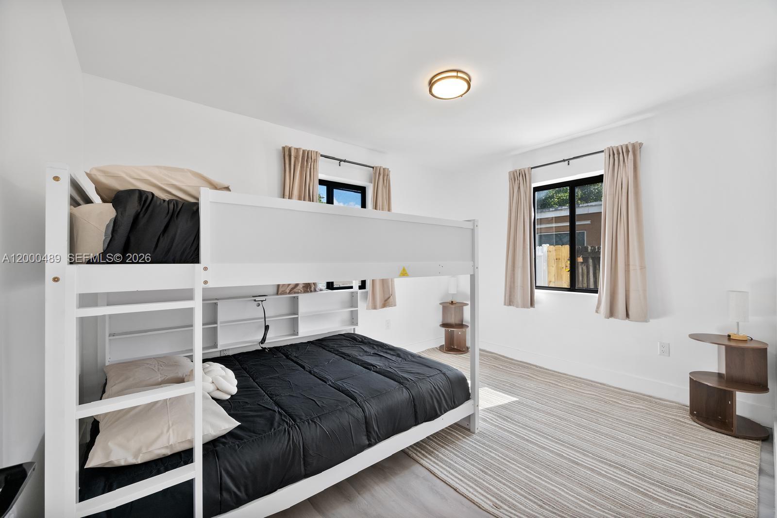 11730 Northwest 3rd Avenue Miami, FL 33168 - Photo 21 of 39 a bedroom with a bed and wooden floor