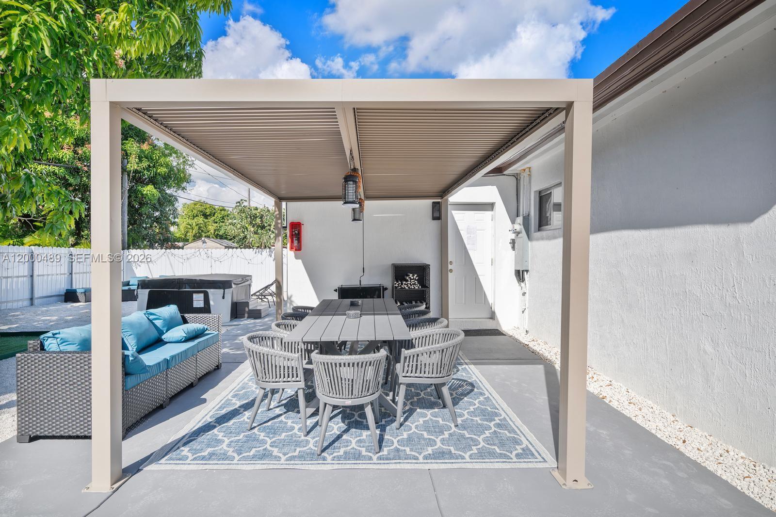 11730 Northwest 3rd Avenue Miami, FL 33168 - Photo 26 of 39 a view of a patio with a dining table and chairs with wooden floor