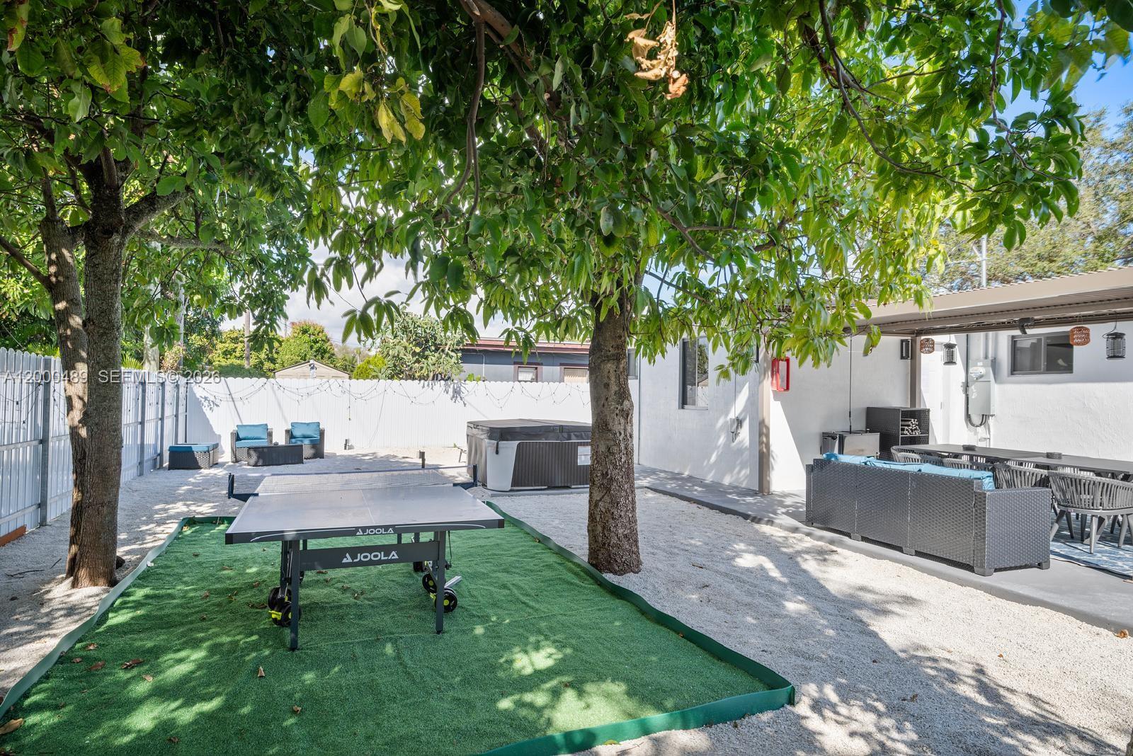 11730 Northwest 3rd Avenue Miami, FL 33168 - Photo 29 of 39 a view of a backyard with chairs potted plants and a large tree