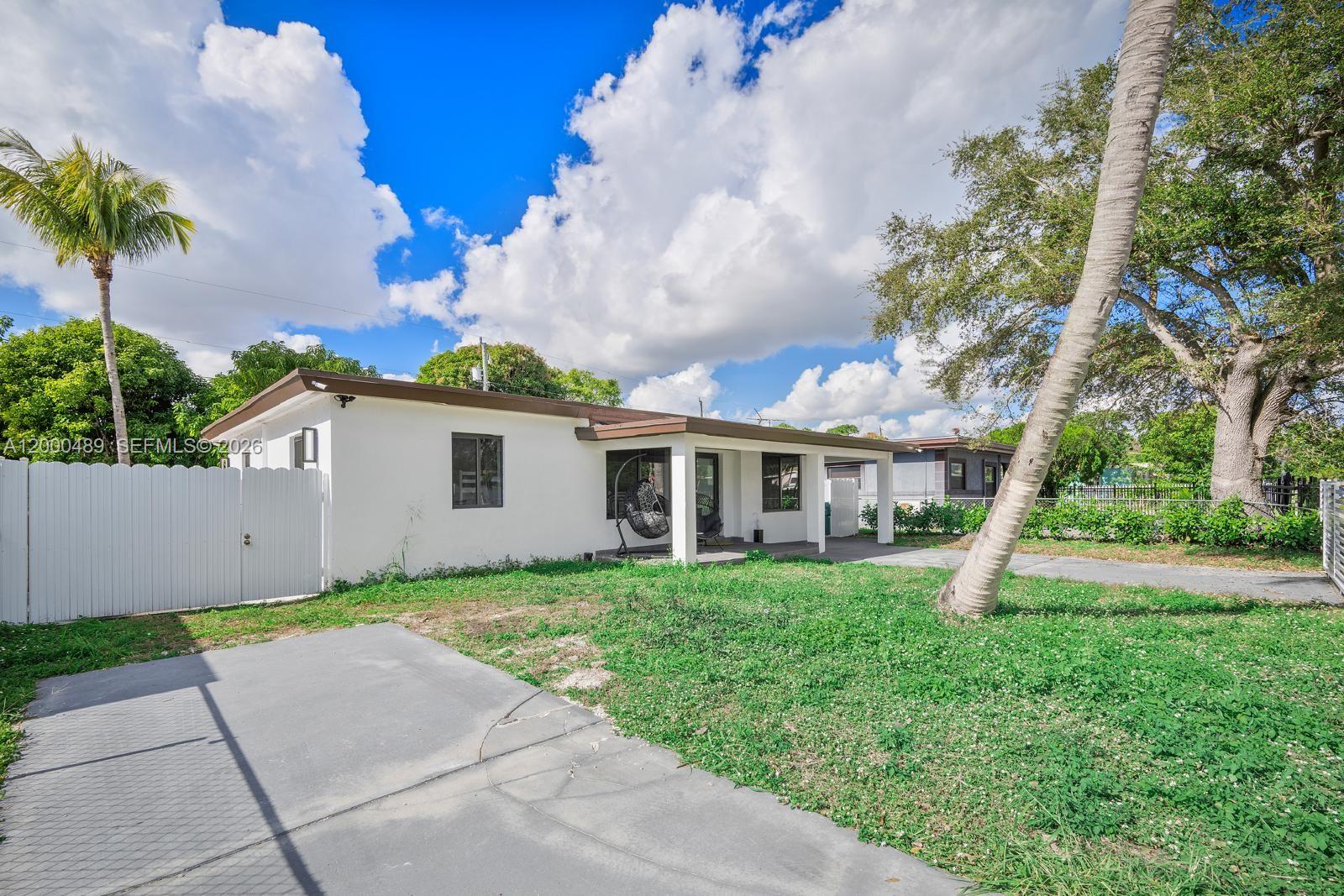 11730 Northwest 3rd Avenue Miami, FL 33168 - Photo 37 of 39 a front view of a house with a yard and trees