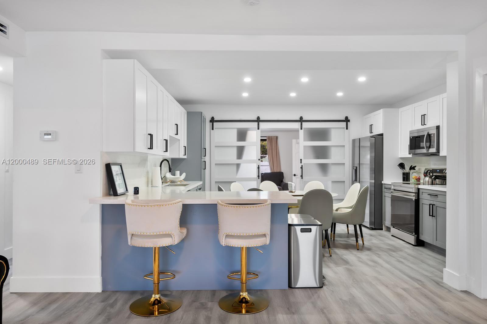 11730 Northwest 3rd Avenue Miami, FL 33168 - Photo 5 of 39 a kitchen with stainless steel appliances kitchen island hardwood floor and center island