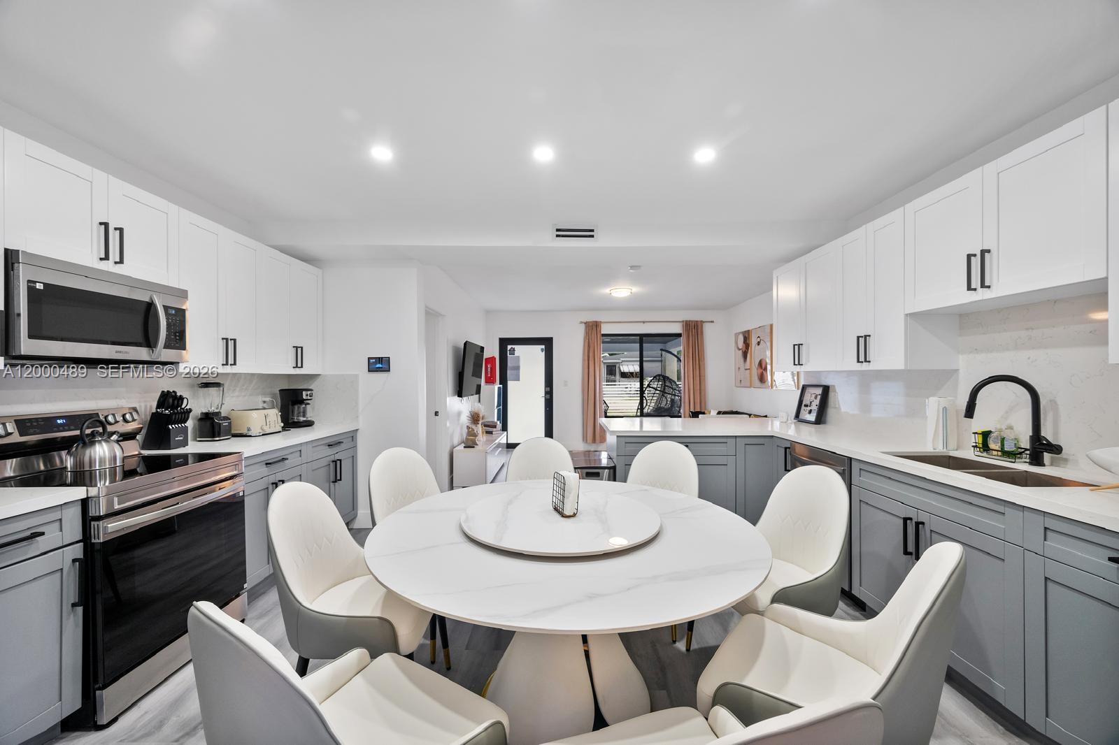 11730 Northwest 3rd Avenue Miami, FL 33168 - Photo 6 of 39 a kitchen with a dining table and chairs