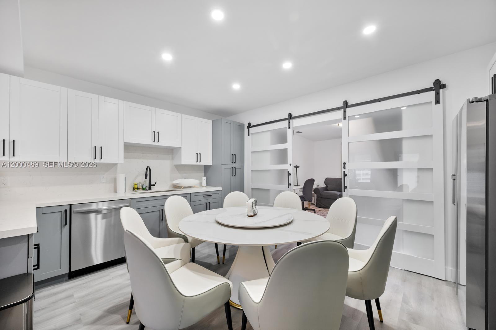 11730 Northwest 3rd Avenue Miami, FL 33168 - Photo 9 of 39 a kitchen with a dining table chairs and white cabinets