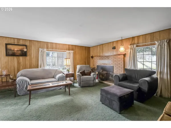 a living room with furniture a large window and a fireplace