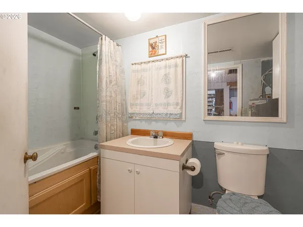 a bathroom with a sink a toilet a mirror a vanity and bathtub