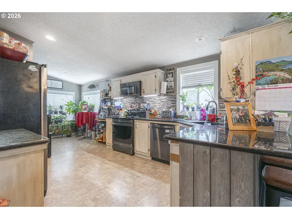a kitchen view with appliances a counter space and a window