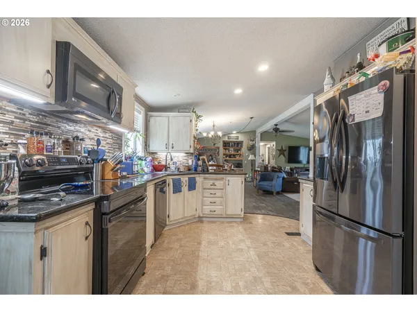 a kitchen that has a lot of cabinets a sink and appliances