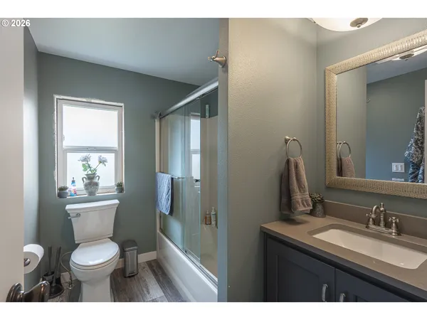 a bathroom with a granite countertop toilet sink and mirror