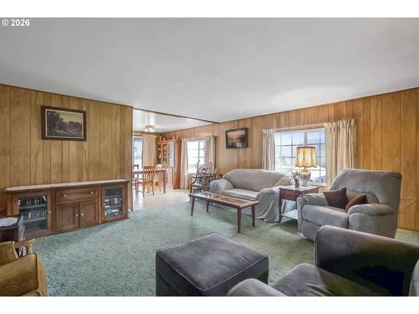 a living room with furniture a rug and a window