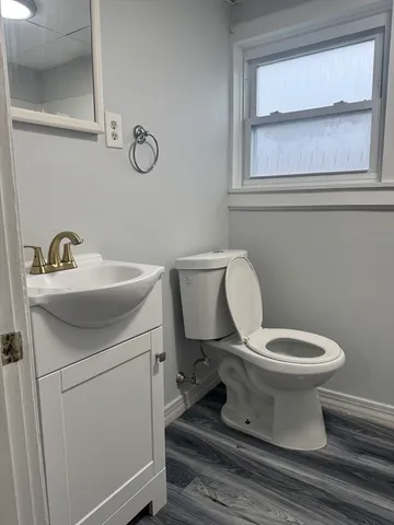 a bathroom with a toilet sink and mirror