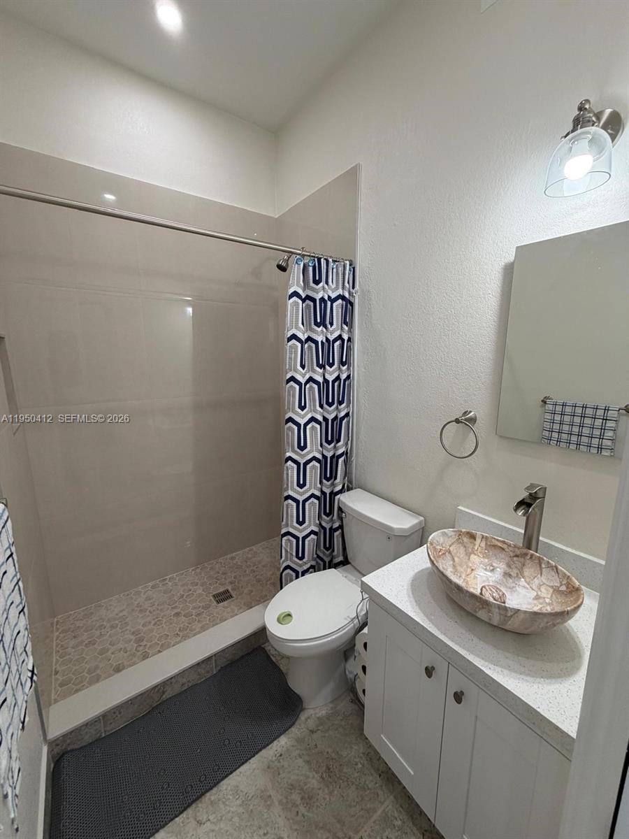 27264 Southwest 132nd Place, Unit A Homestead, FL 33032 - Photo 4 of 10 a bathroom with a sink a toilet and shower