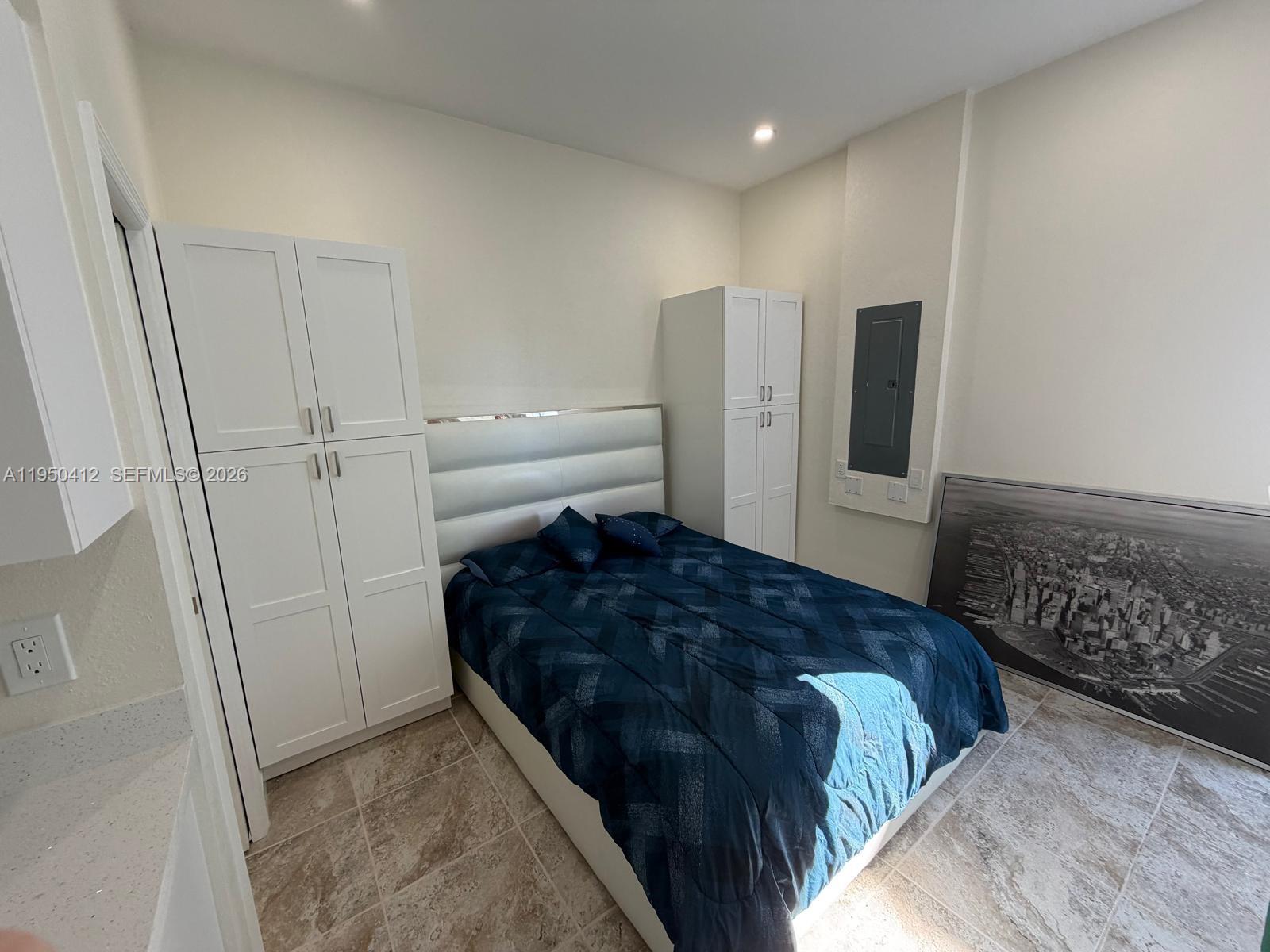 27264 Southwest 132nd Place, Unit A Homestead, FL 33032 - Photo 7 of 10 a bedroom with a bed and cabinets