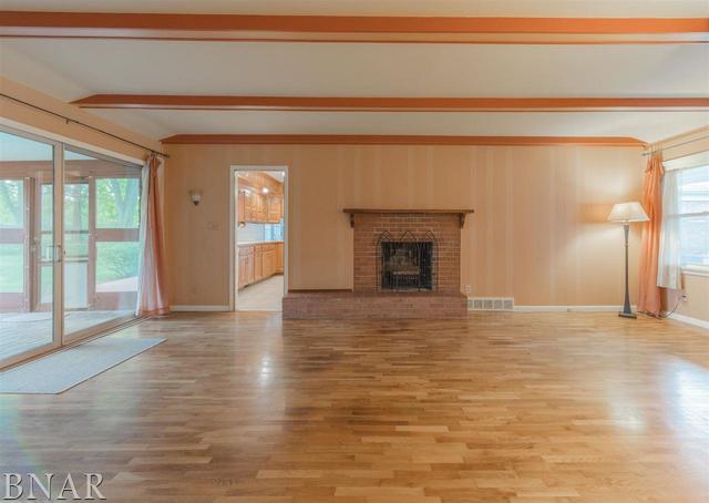 14016 Dry Grove Road Bloomington, IL 61705 - Photo 5 of 43 a view of empty room with wooden floor and fireplace