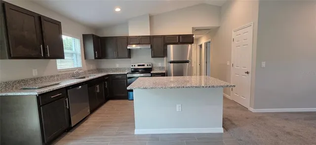 a kitchen with stainless steel appliances a sink stove and refrigerator