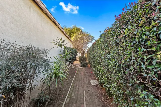 a view of a house with a yard and potted plants