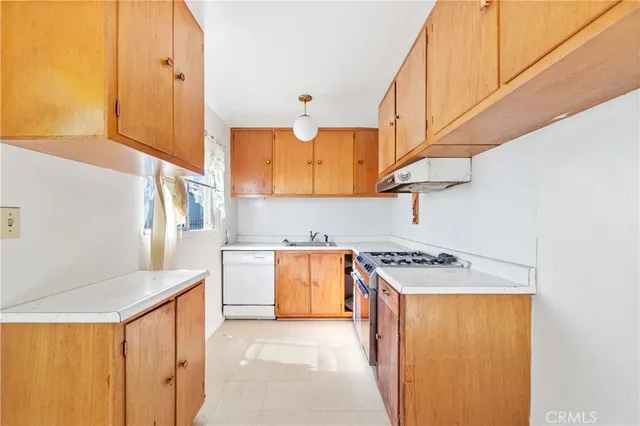 a utility room with sink a stove and a refrigerator