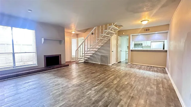 an empty room with wooden floor and a window